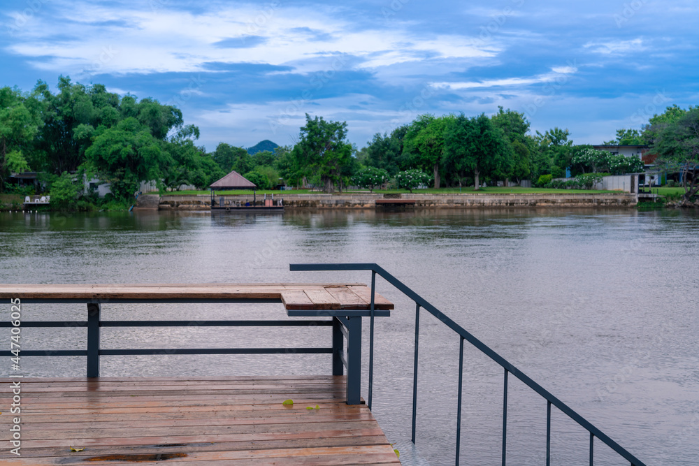 wooden seat terrace with view of river Kwai in Kanchanaburi, Thailand. calm waterfront with fresh green forest