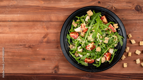 Foto Rocket salad with tomato, crispy crouton, small pieces of herb roasted chicken a