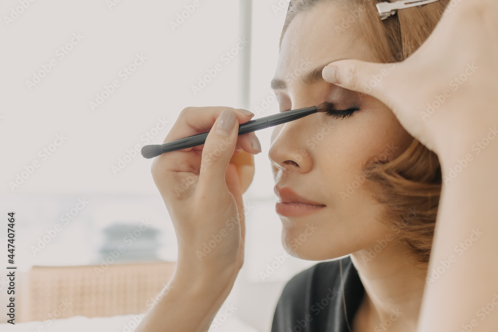 The makeup artist is applying makeup on client eyes. The makeup artist is applying makeup on client eyes.