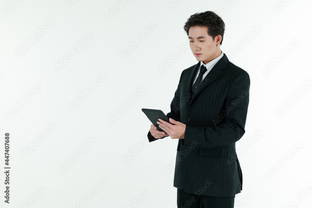 Portrait of self confidence young and handsome business Asian man in black suit holding tablet computer with copy space studio shot isolated on white background Portrait of self confidence young and handsome business Asian man in black suit holding tablet computer with copy space studio shot isolated on white background