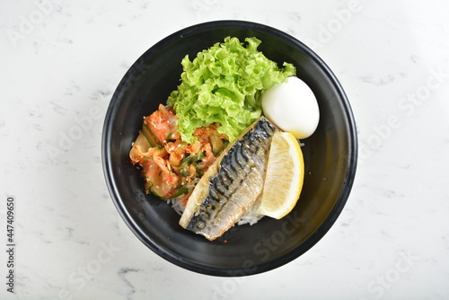 bbq grill korean saba fish seafood with lemon, boiled egg, kimchi and rice bowl in black bowl in white marble healthy poke bowl menu