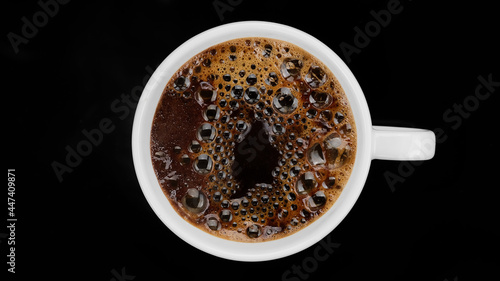 Hot black coffee in white cup on black background, top view