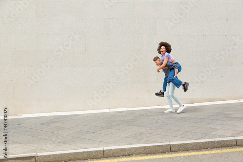 Caucasian young man carrying afro woman on his back smiling © luisrojasstock