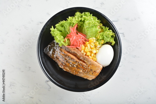 japanese bbq grill teriyaki salmon seafood with boiled egg, corn, red ginger and rice bowl with onsen egg in black bowl in white marble healthy poke bowl menu