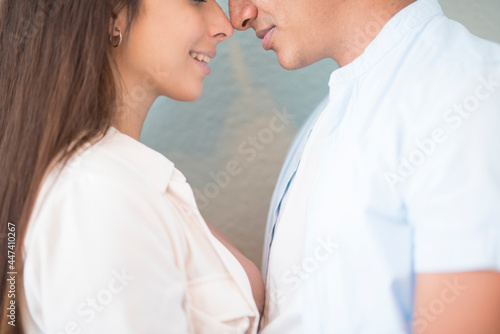 Mixed race couple close touching nose each other - love and relationship concept with young man and woman - boyfriend girlfriend together - friendship millennial boy and girl