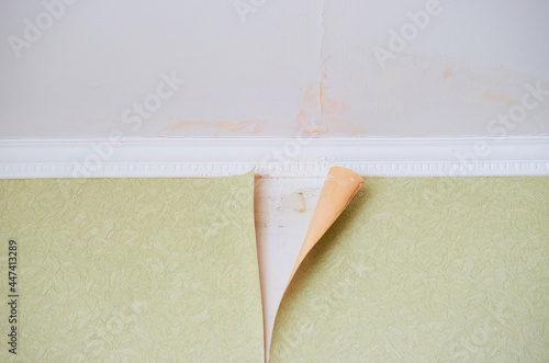 Removing old paper wallpaper from the wall in a room of a residential building