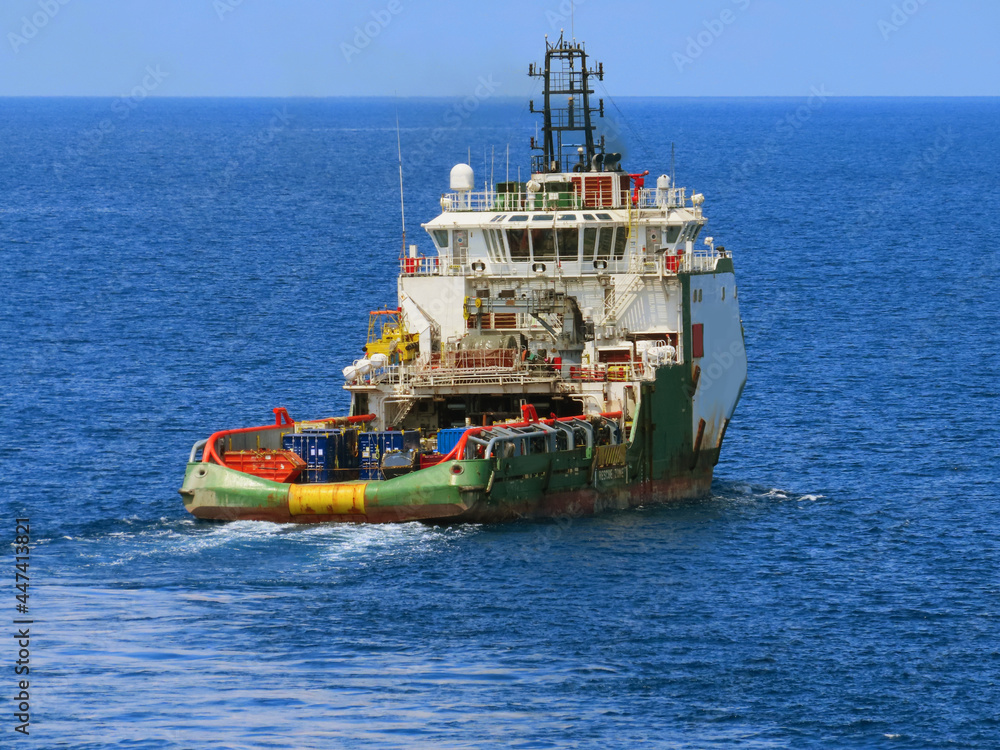 Supply boat transfer cargo to oil and gas industry and moving cargo from the boat to the platform. Boat is waiting transfer cargo and crews to platform.