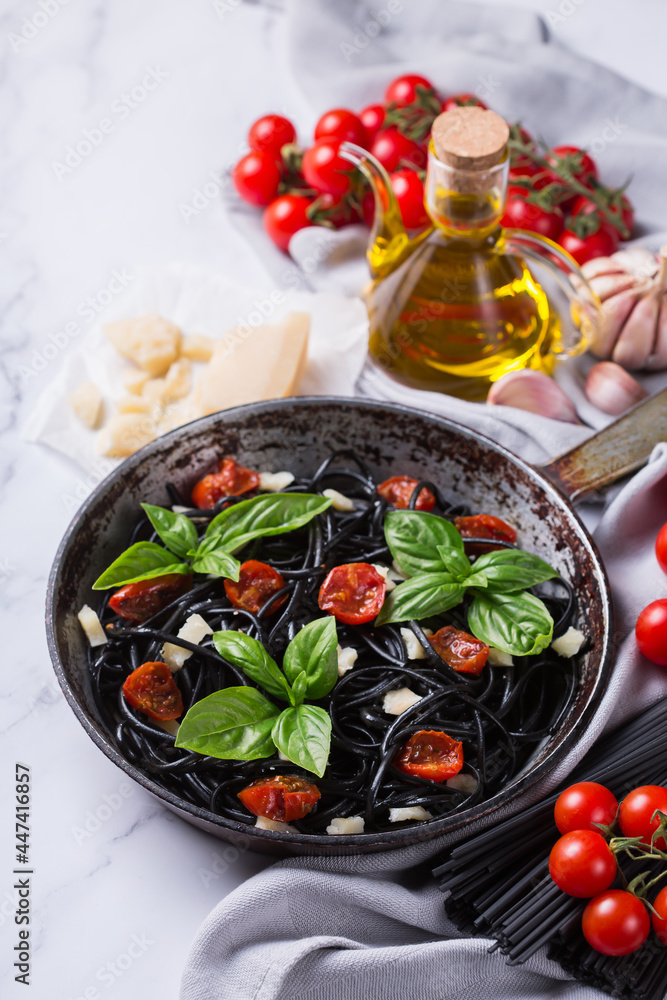 Black spaghetti pasta with tomatoes, cheese and basil