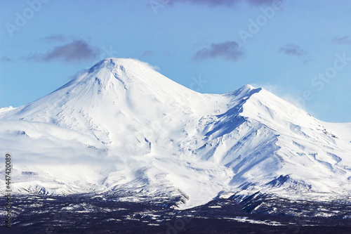 Kamchatka Peninsula. Natural Park of Russia "Three volcanoes" shooting from the air. Volcanoes covered with snow. international resort interesting for Russian and foreign tourists.