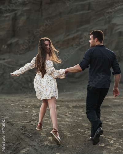 Couple of lovers holding hands and running away