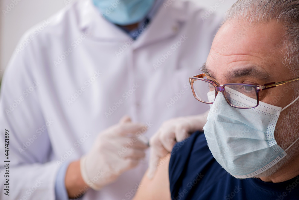 Old male patient visiting young male doctor in vaccination conce Old male patient visiting young male doctor in vaccination conce