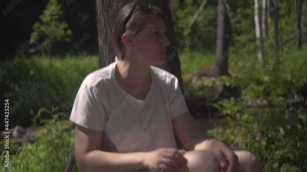 Tired Woman Hicker Stopped at a Halt in the Pine Forest. Tourist in Sunglasses and White T-shirt Resting. Generation z new concept travels Tired Woman Hicker Stopped at a Halt in the Pine Forest. Tourist in Sunglasses and White T-shirt Resting. Generation z new concept travels