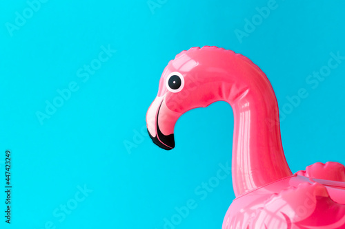Pink, trendy, exploded beach flamingo on a blue background. Copy space. Hit in the summer