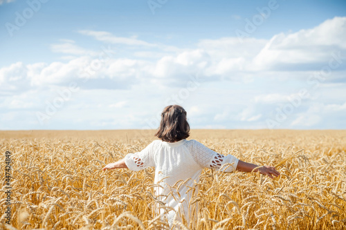фотографія Mature woman in   white dress in   field of cereals on   summer day