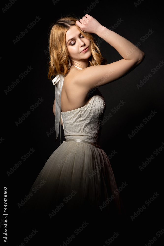 Beautiful bride. Festive look. Model shooting. Party celebration. Smiling elegant woman in romantic white dress bare shoulder posing isolated black light shadow.