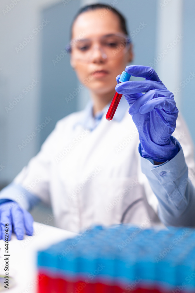 Specialist woman doctor holding blood medical vacutainer analyzing dna infection expertise researching microbiology diagnostic experiment. Researcher chemist working in medicine hospital laboratory Specialist woman doctor holding blood medical vacutainer analyzing dna infection expertise researching microbiology diagnostic experiment. Researcher chemist working in medicine hospital laboratory