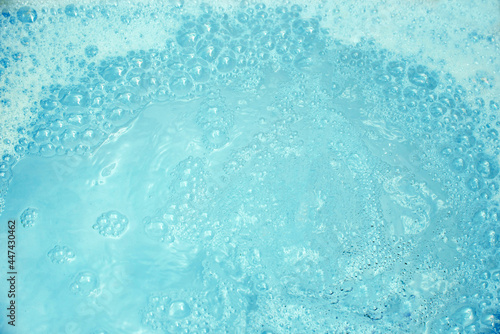 Background of blue water with foam and bubbles.