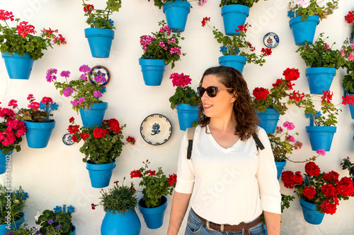 Portrait of a beautiful woman in Andalusian wall decoration with typical blue pots flowers on facades photo