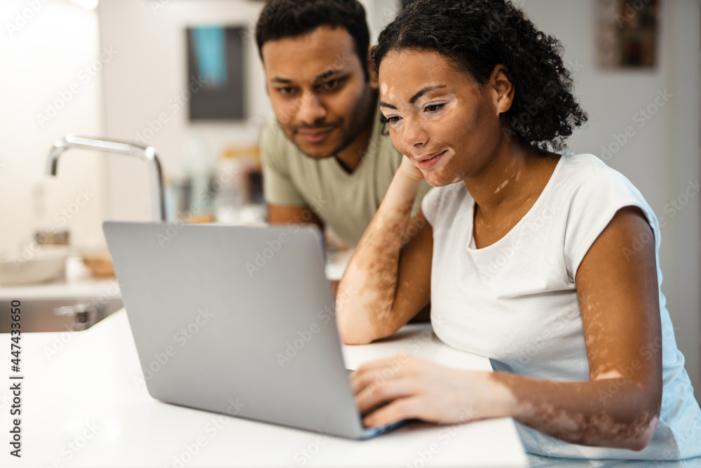 Middle eastern man and woman working with laptop together at home
