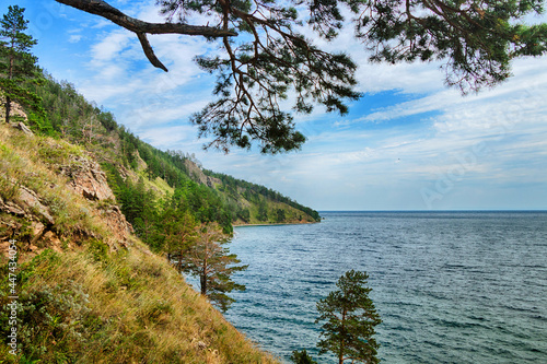 A beautiful natural landscape with a lake, shore and rocks in summer, warm sunny weather.