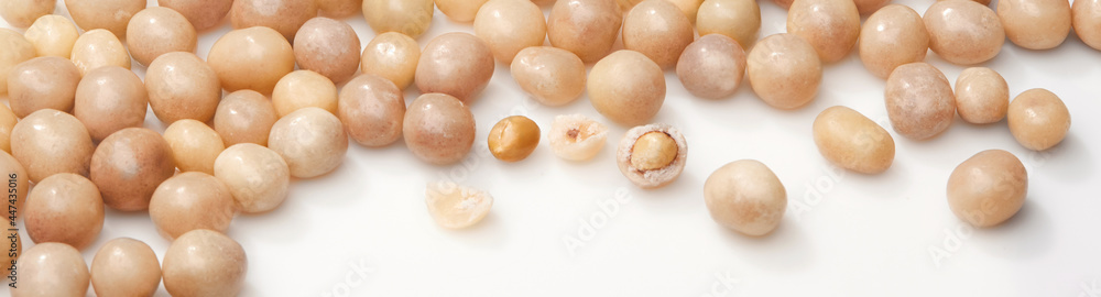 Sweet roasted peanuts in sugar glaze on white surface Sweet roasted peanuts in sugar glaze on white surface