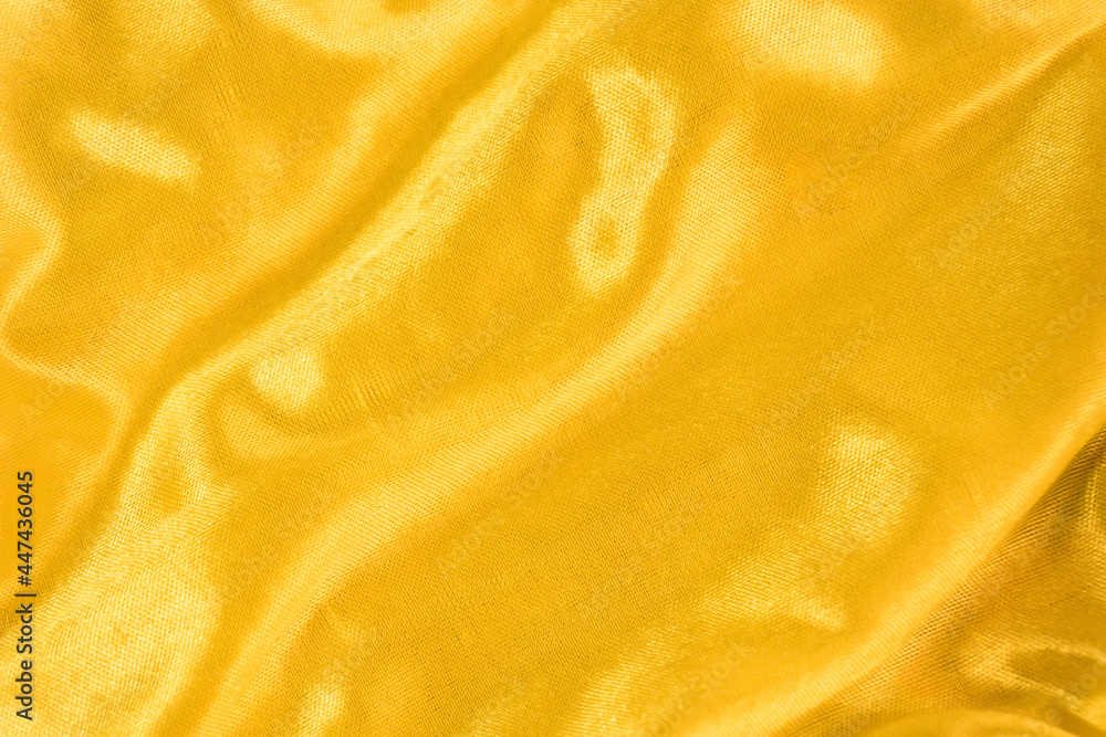 Golden silk or satin texture. Smooth elegant and luxury fabric background with copy space. Golding liquid Golden silk or satin texture. Smooth elegant and luxury fabric background with copy space. Golding liquid