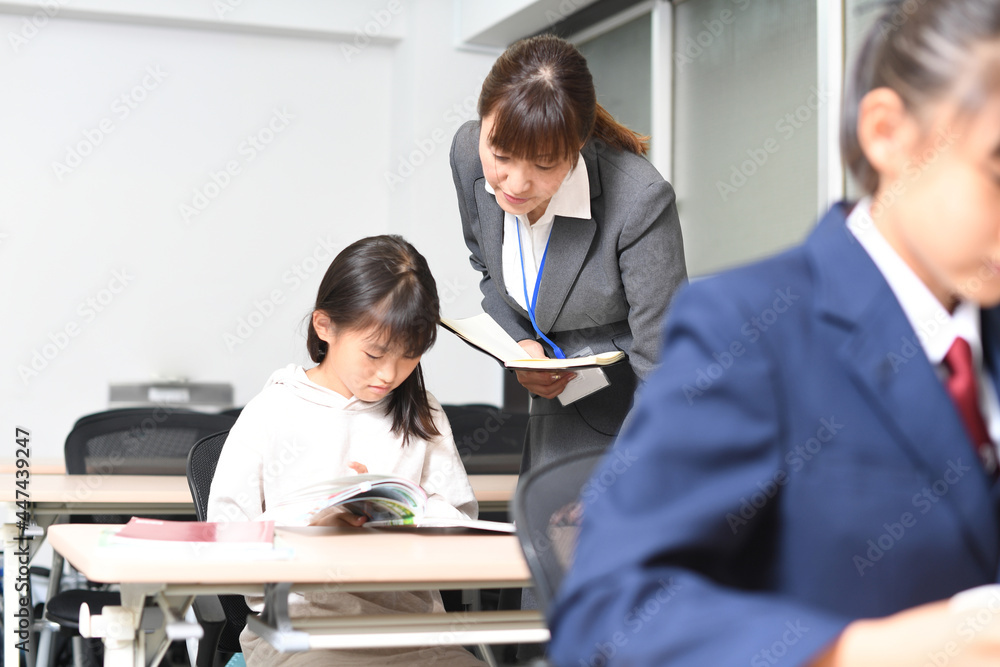 授業中に勉強をする女子学生と塾講師のイメージ