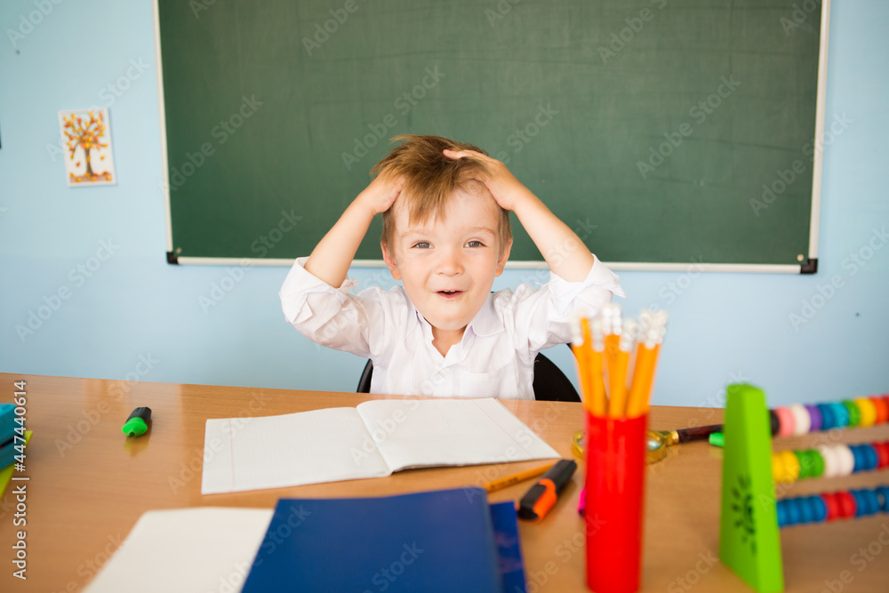 Back to school concept. Funny tired schoolboy ponders the difficult task Back to school concept. Funny tired schoolboy ponders the difficult task
