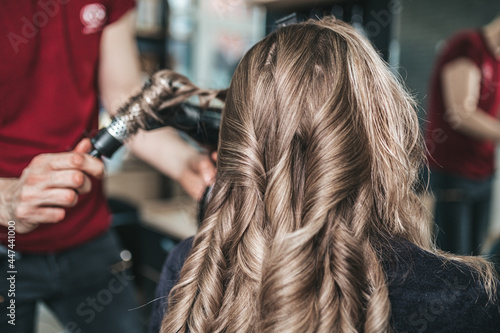 Beautiful hairstyle of woman after dyeing hair and making highlights in hair salon.