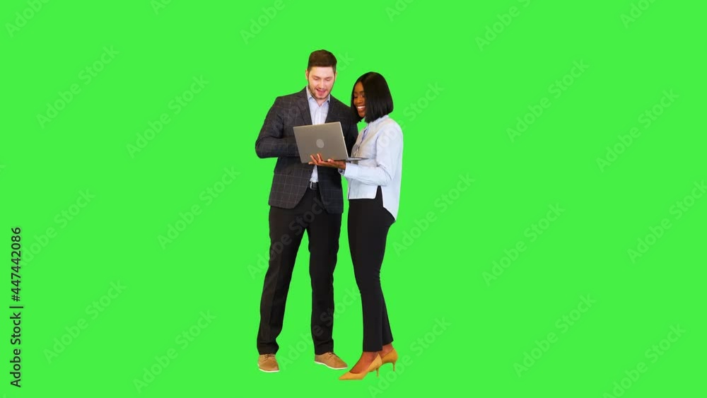 Overjoyed business man and woman look on laptop get extremely happy of project success and benefits on a Green Screen, Chroma Key. Overjoyed business man and woman look on laptop get extremely happy of project success and benefits on a Green Screen, Chroma Key.