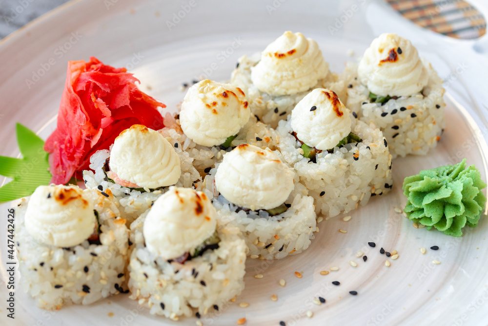 Japanese sushi with sesame seeds and cream icing on gray background Japanese sushi with sesame seeds and cream icing on gray background