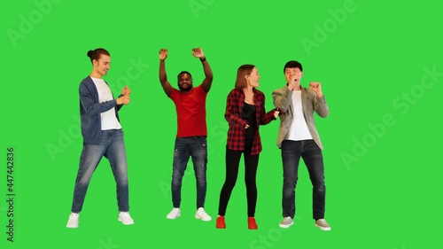 Multiethnic group of young friends dancing on a Green Screen, Chroma Key. photo