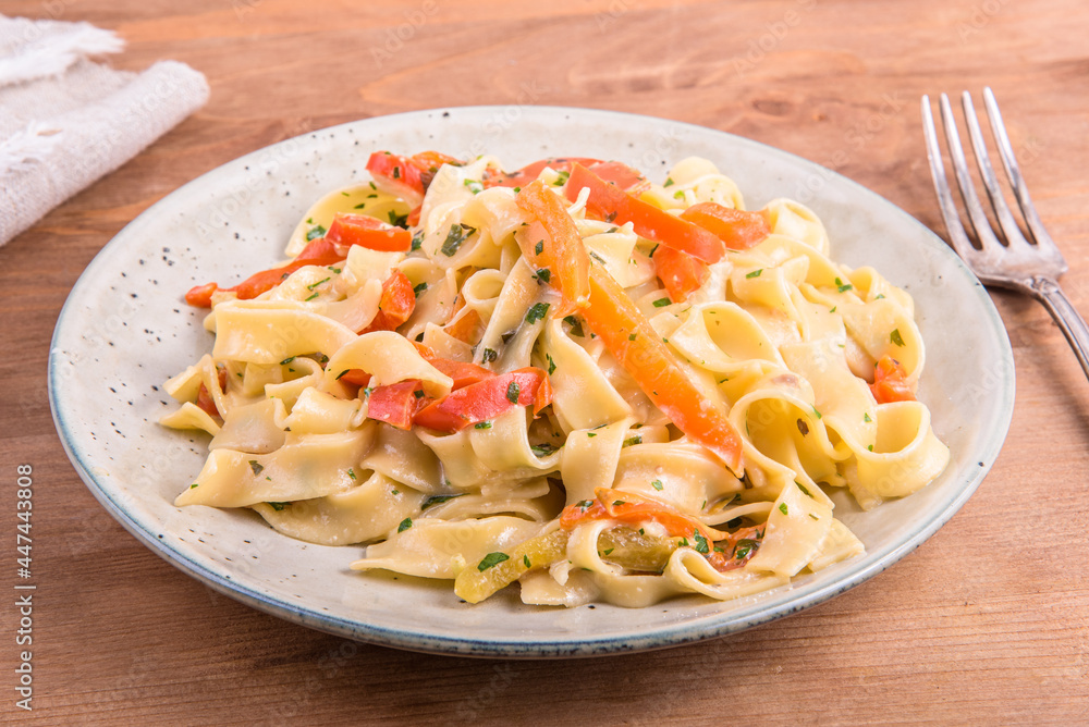 Pasta with cream sauce with bell pepper on a plate, close-up - fettuccine with bell pepper Pasta with cream sauce with bell pepper on a plate, close-up - fettuccine with bell pepper