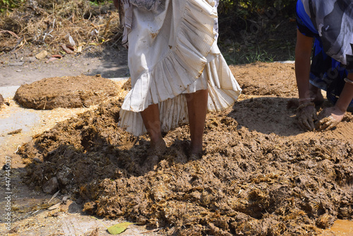 feet of a woman while trampling the soil to build a wall