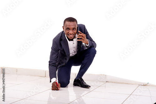 Schilderij op canvas young businessman talking on mobile phone and writing on the floor smiling
