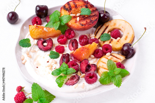 Grilled peach and apple in cottage cheese cream topped with raspberry, cherry, mint and pine nuts. Served summer dessert
