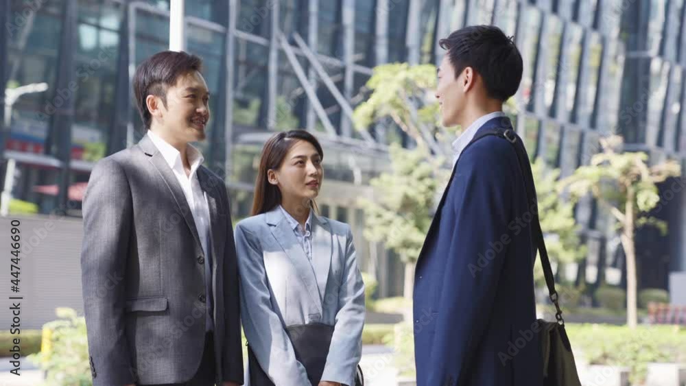 team of three asian corporate office worker standing talking on street in downtown financial district of modern city team of three asian corporate office worker standing talking on street in downtown financial district of modern city