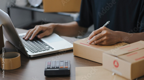 Young man entrepreneur small business SME Freelance receive order client and working with packaging sort box delivery online market on purchase order and preparing package product parcel for shipment