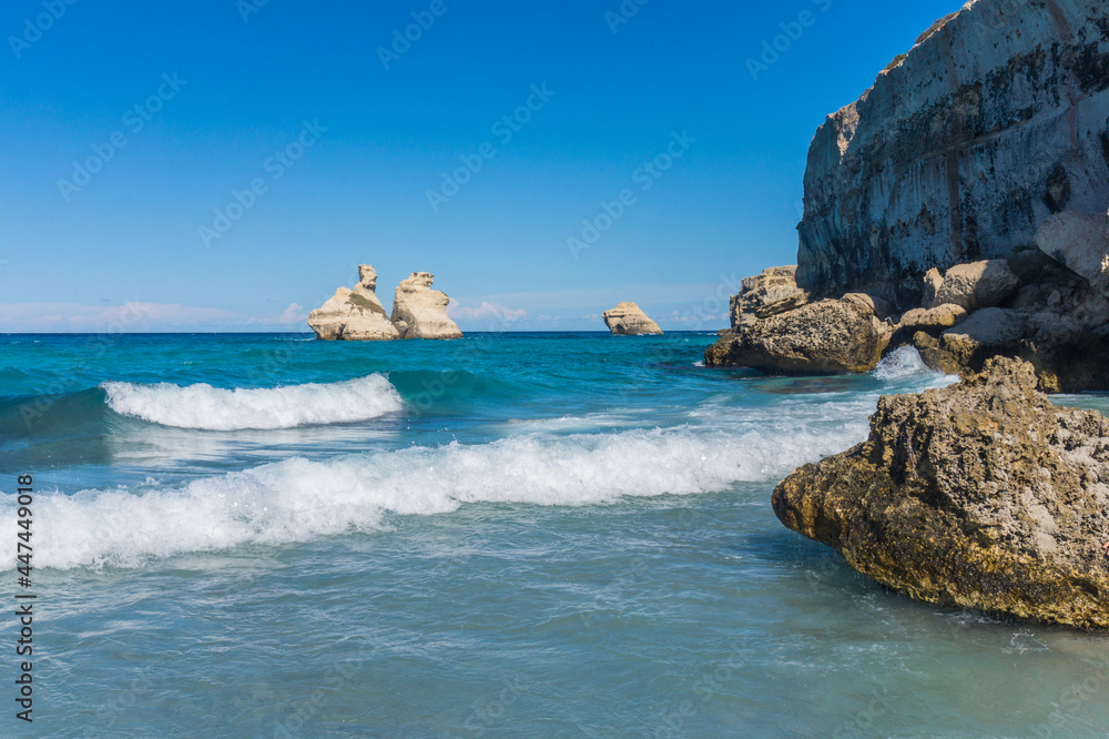 Beach of Torre dell'Orso, Salento coast, Lecce, Apulia, Italy. Two Sisters Rocks, clear blue water and cliffs view. No people.