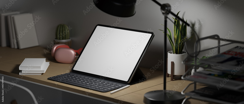 Late night overwork, Side view of empty screen tablet with keyboard in low light home office Late night overwork, Side view of empty screen tablet with keyboard in low light home office