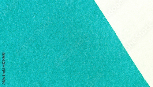 Two tone background of felt fabric texture background in green turquoise and white colors with copy space.