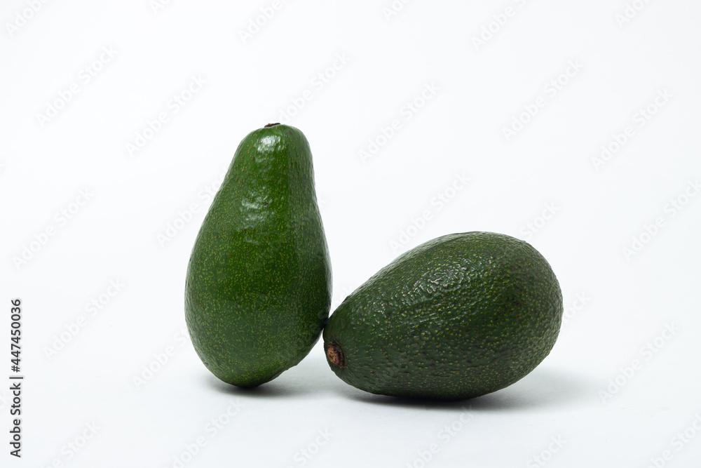 Two whole avocados on a white background. Isolated green avocado. Two whole avocados on a white background. Isolated green avocado.