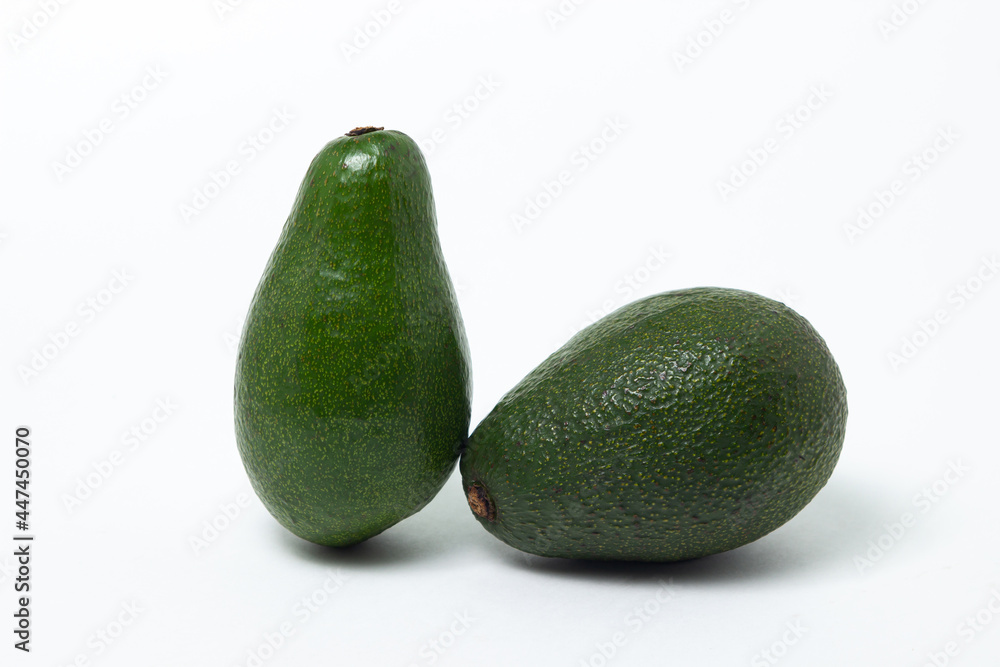 Two whole avocados on a white background. Isolated green avocado. Two whole avocados on a white background. Isolated green avocado.