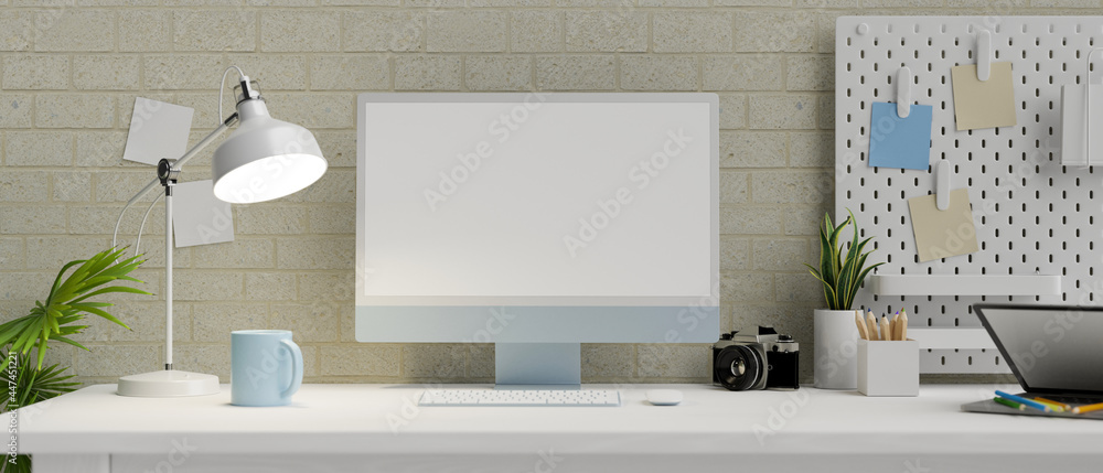 Modern apartment work space with desktop computer in empty screen and stuff in front of modern brick wall Modern apartment work space with desktop computer in empty screen and stuff in front of modern brick wall