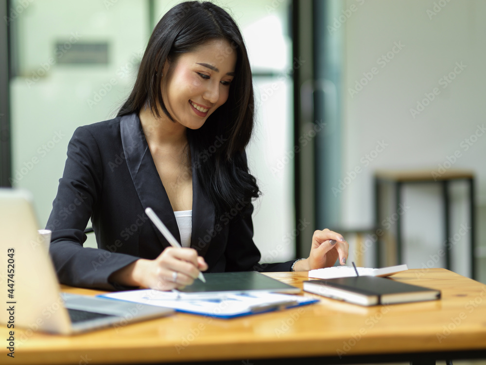 Young asian CEO female calculating project budget via smart digital tablet Young asian CEO female calculating project budget via smart digital tablet