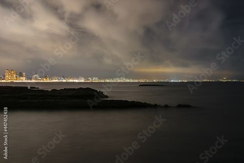 Dismal night seascape and cityscape longexpo