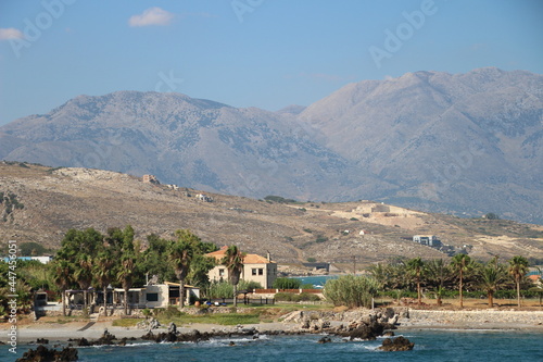 Village on the coast of island with mountains in background