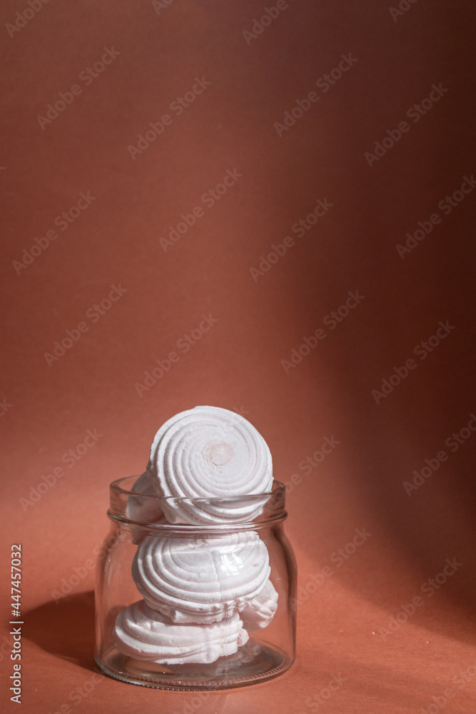 pink marshmallows in a glass jar against brown background, natural sunlight
pink marshmallows in a glass jar against brown background, natural sunlight