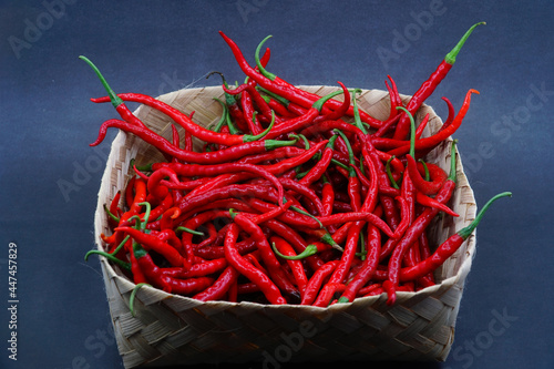 Red chili pepper in a bamboo basket isolated on a black background, focus select фототапет