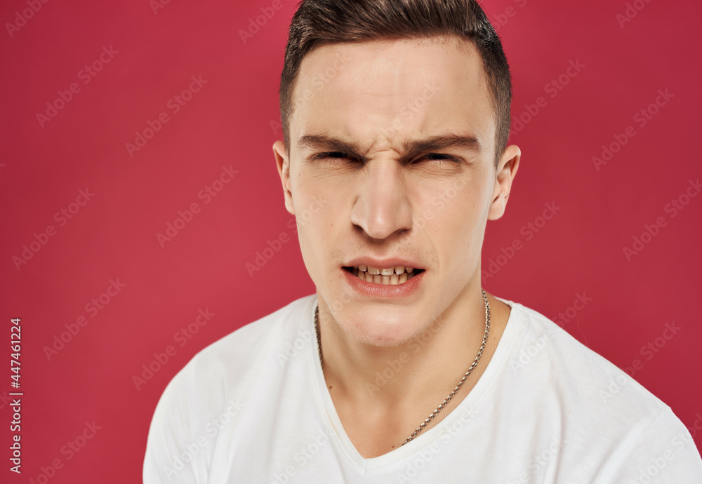 Fototapeta premium Angry man emotions white t-shirt close-up flag red background